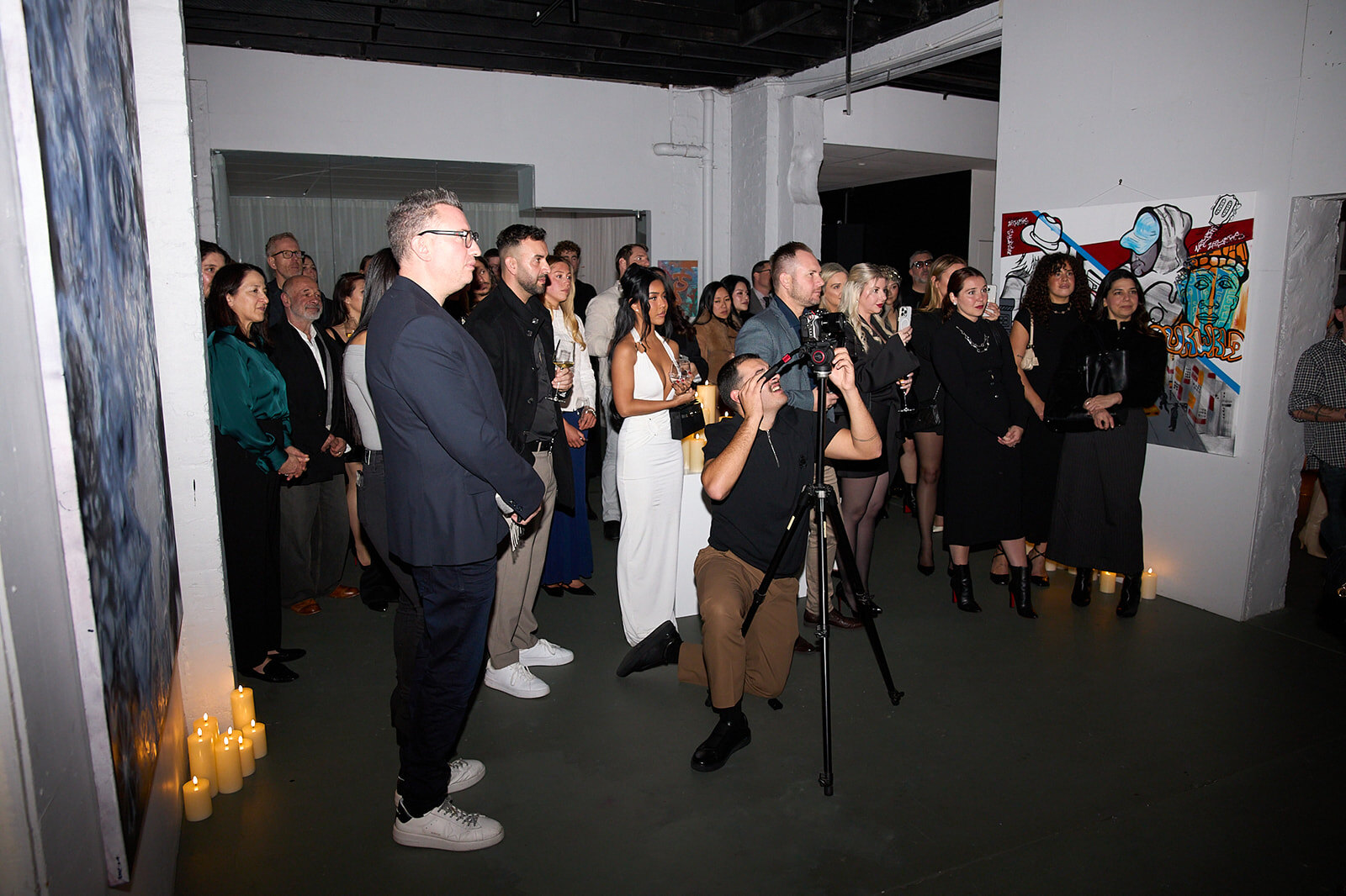 Guests gathered around the work at an opening at La Vita Nova